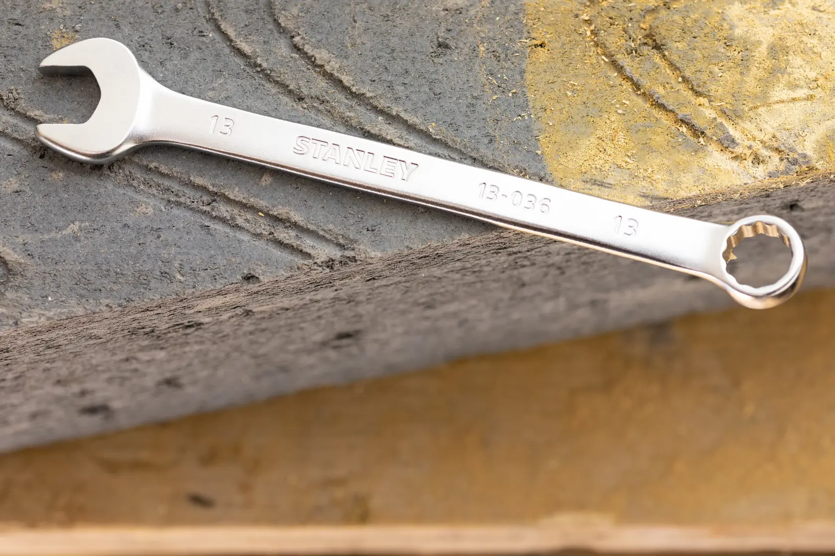 STANLEY FMMT13041-0 combination wrench, silver, 13mm size, photographed on concrete surface.