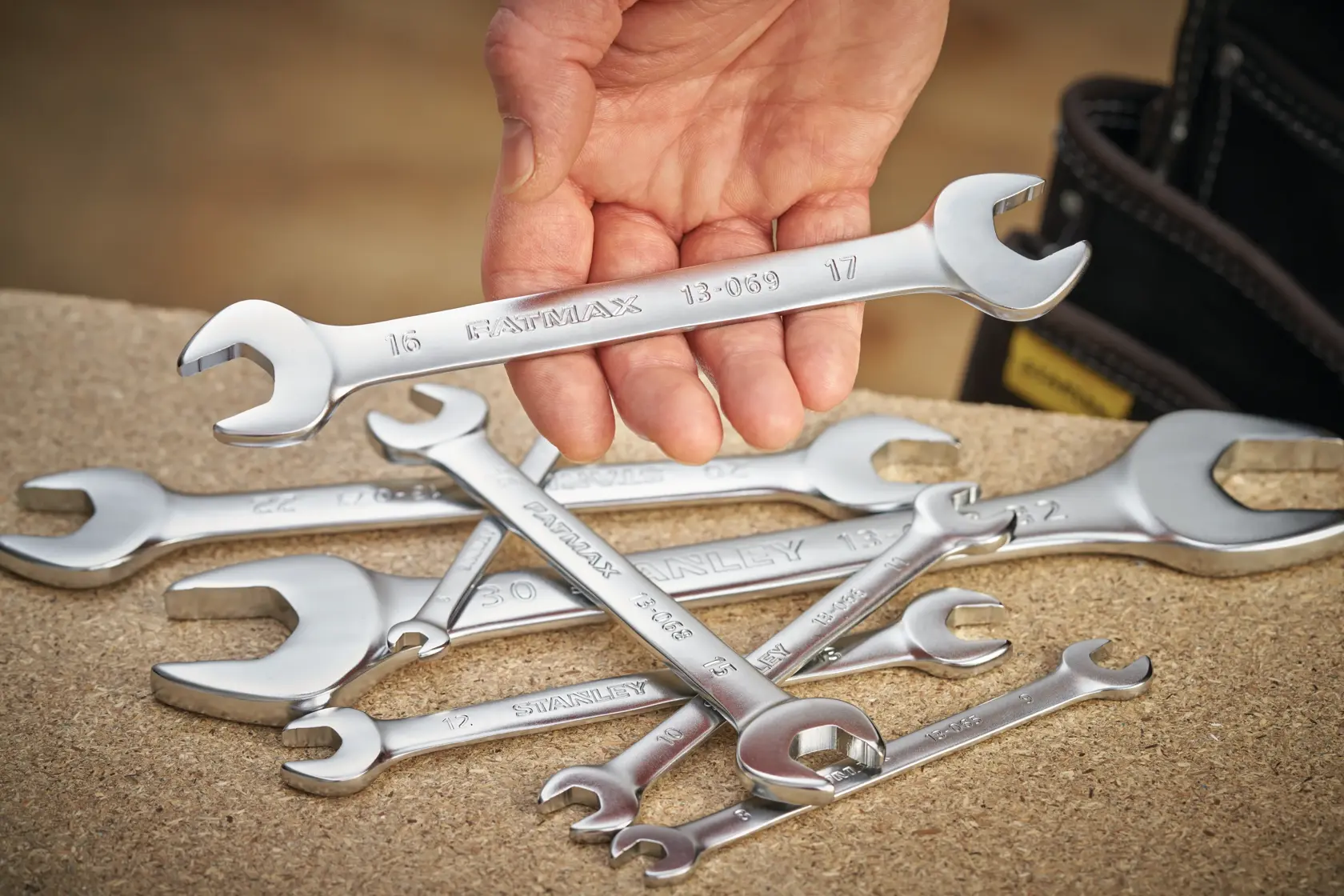 STANLEY FMMT13077-0 photography of silver open-end wrenches, one held by hand, on a work surface.