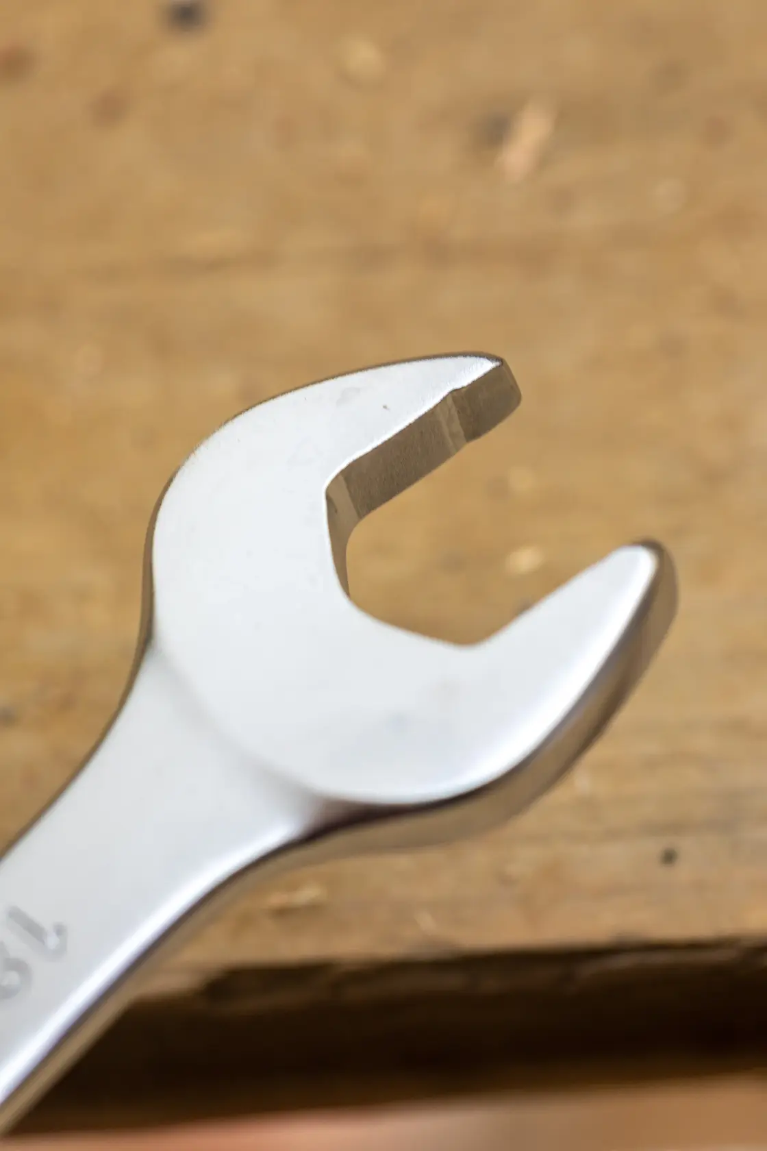 STANLEY FMMT13085-0 open-end wrench, photography of chrome finish tool on wooden surface, angled view.