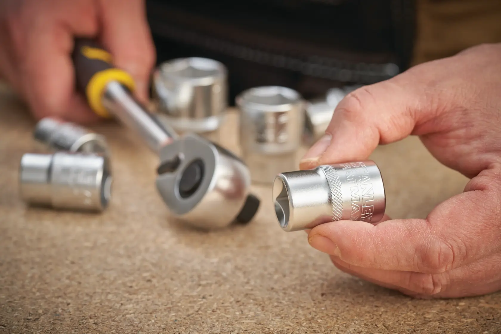 STANLEY FMMT17233-0 socket and ratchet in use, close-up photo, chrome finish, hand-held.