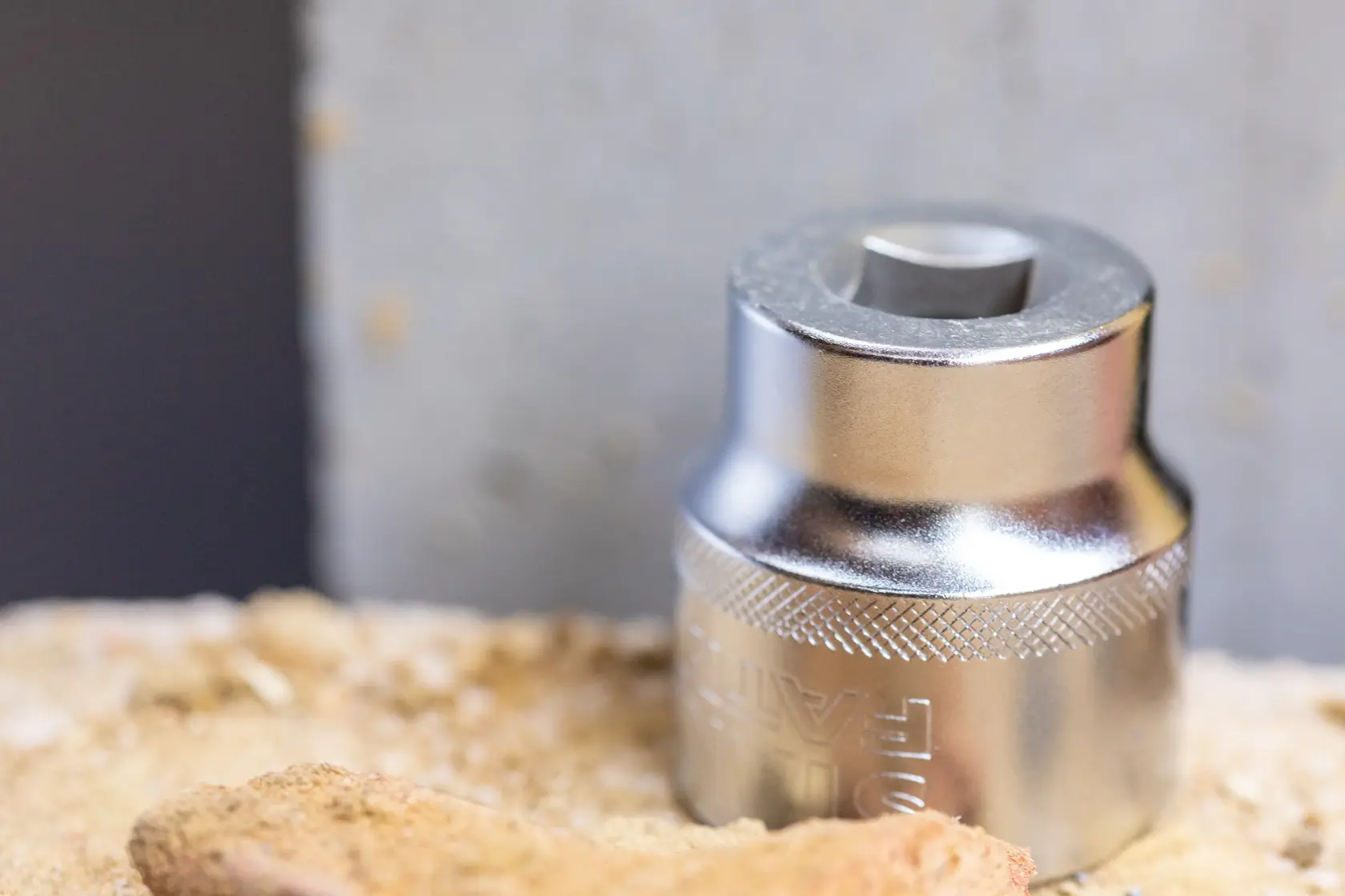 STANLEY FMMT17233-0 shiny metal socket, close-up, photography on sandy surface.