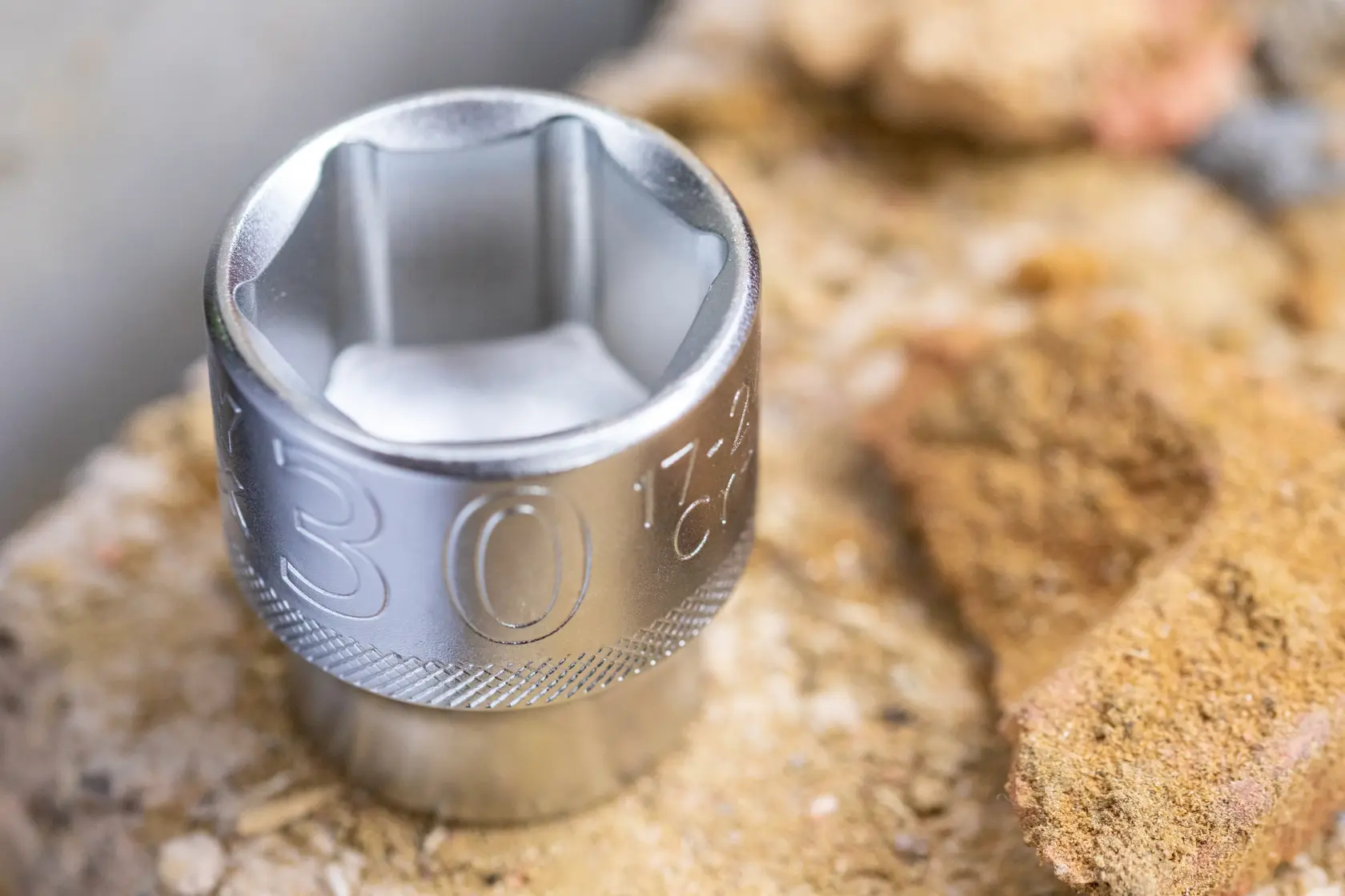 STANLEY FMMT17236-0 chrome socket, close-up view, compact and reflective, on rough stone surface.