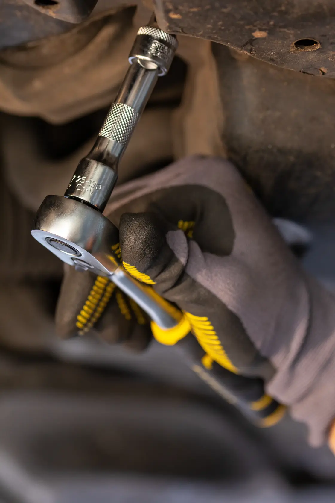 STANLEY FMMT25125-0 ratchet wrench in use, close-up showing gloved hand turning bolt.
