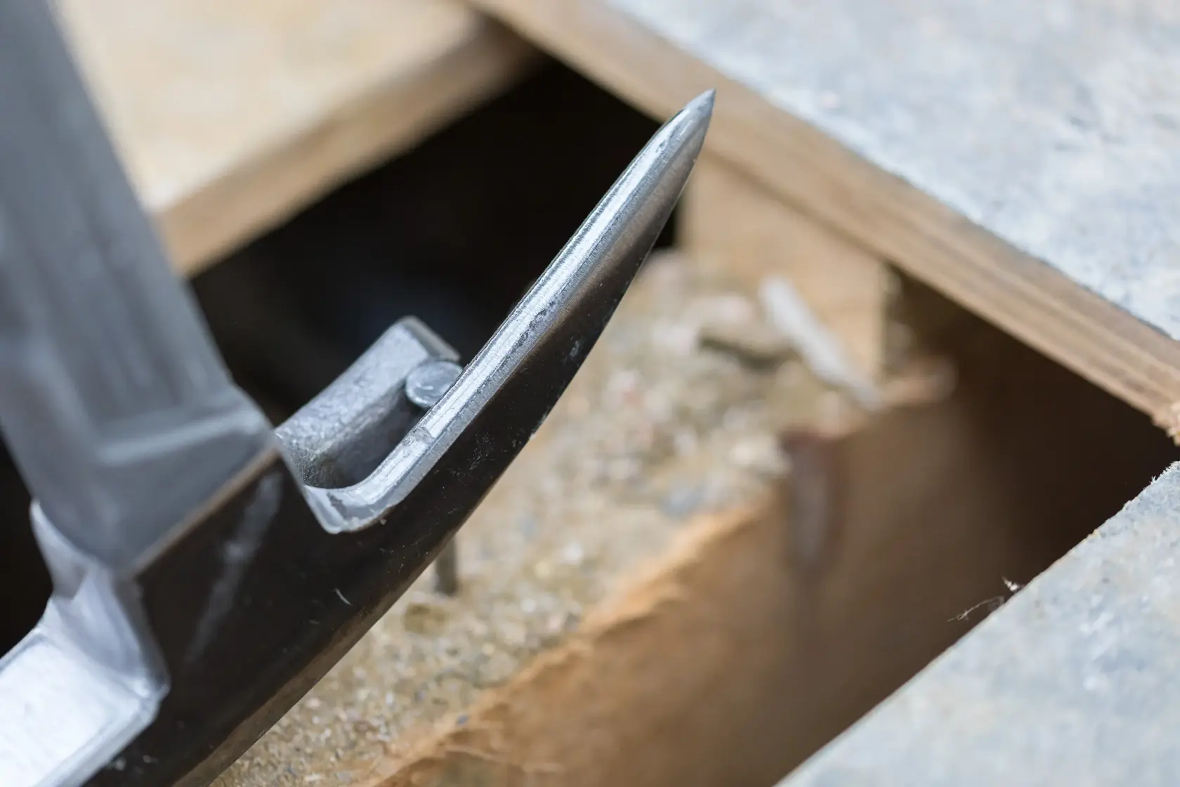Close-up of STANLEY STHT0-51311 claw hammer head beside wooden boards, photography.