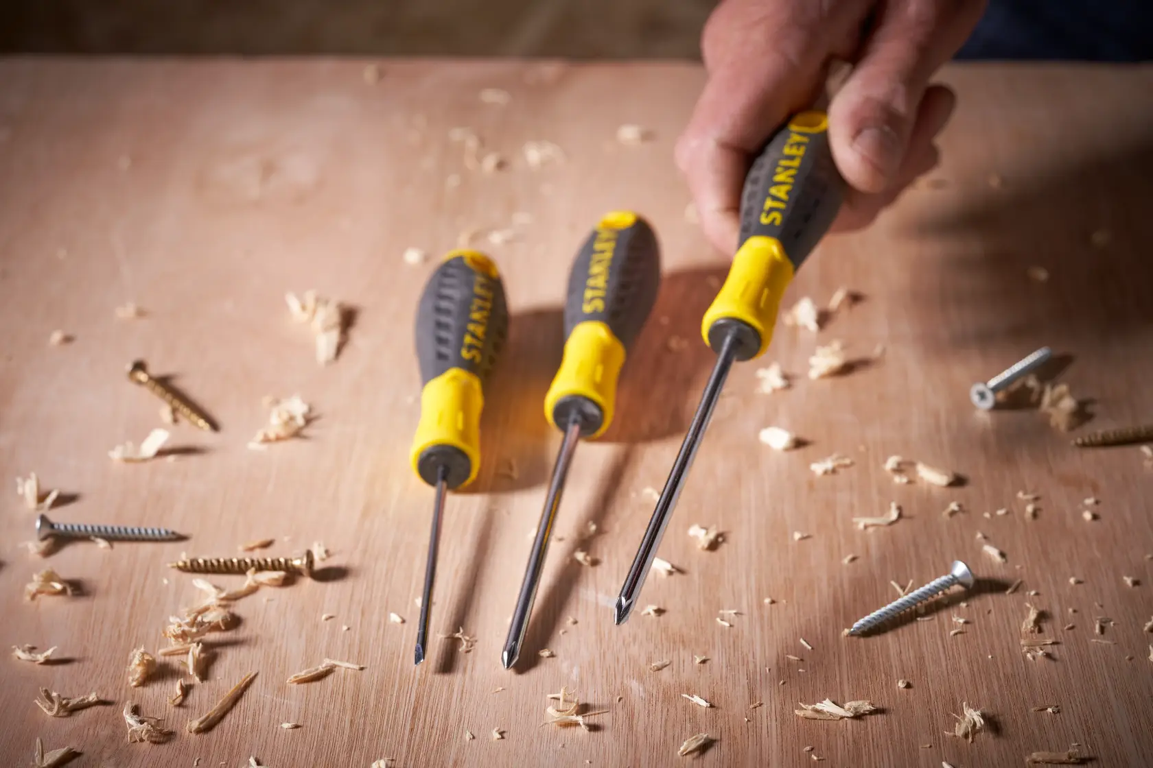 STANLEY STHT0-60276 screwdriver set with yellow and black handles on a wooden surface with screws.