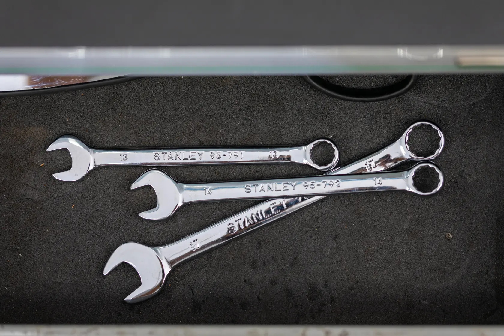 Stanley STMT95791-0 photography of chrome combination wrenches in a toolbox drawer, top view.