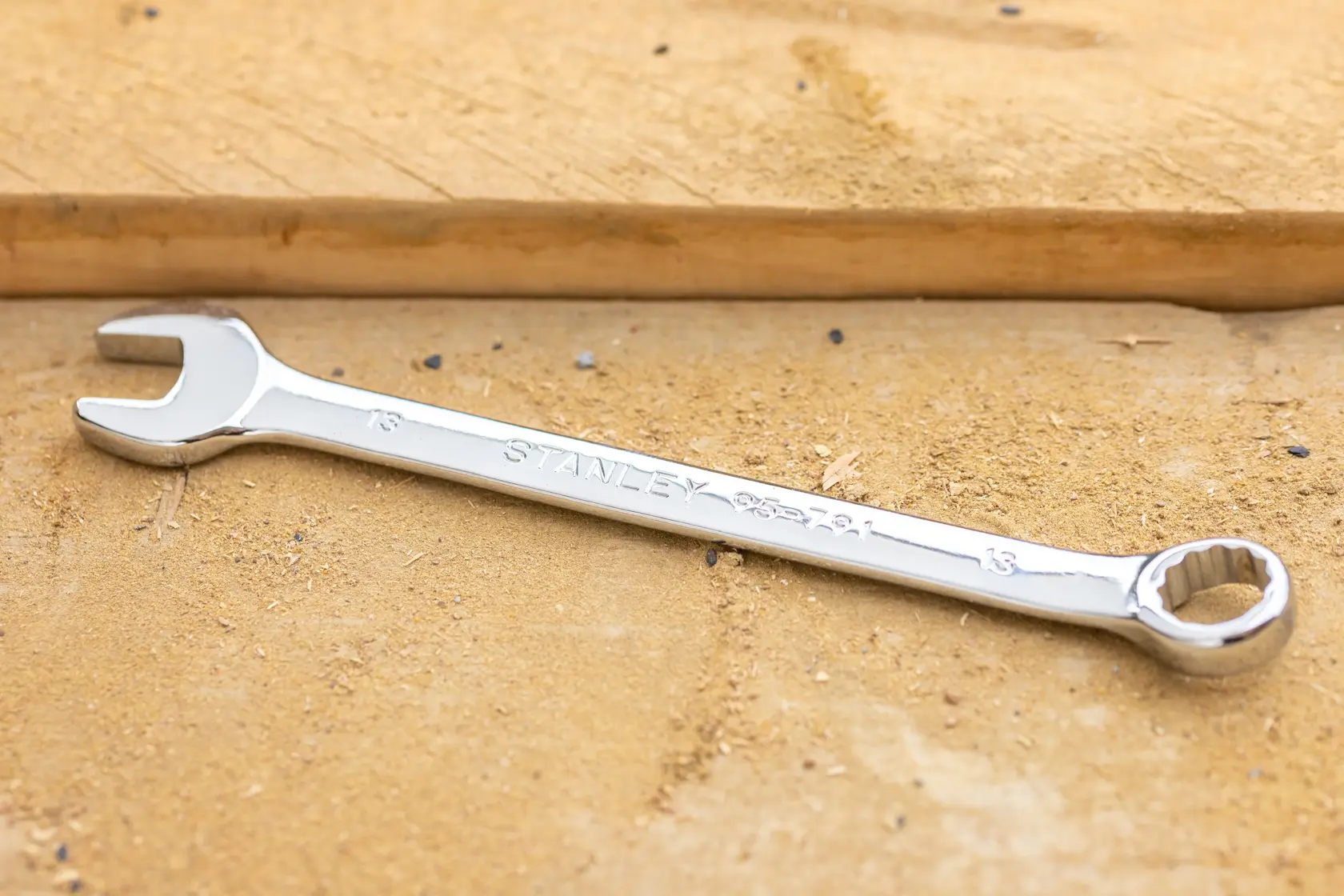 Photo of STANLEY STMT95911-0 combination wrench, 13mm, chrome finish, lying on a wooden surface.
